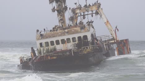 a spooky shipwreck grounded fishing trawler sits in atlantic waves along the skeleton coast of namibia 2