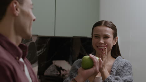 couple sharing apples in kitchen