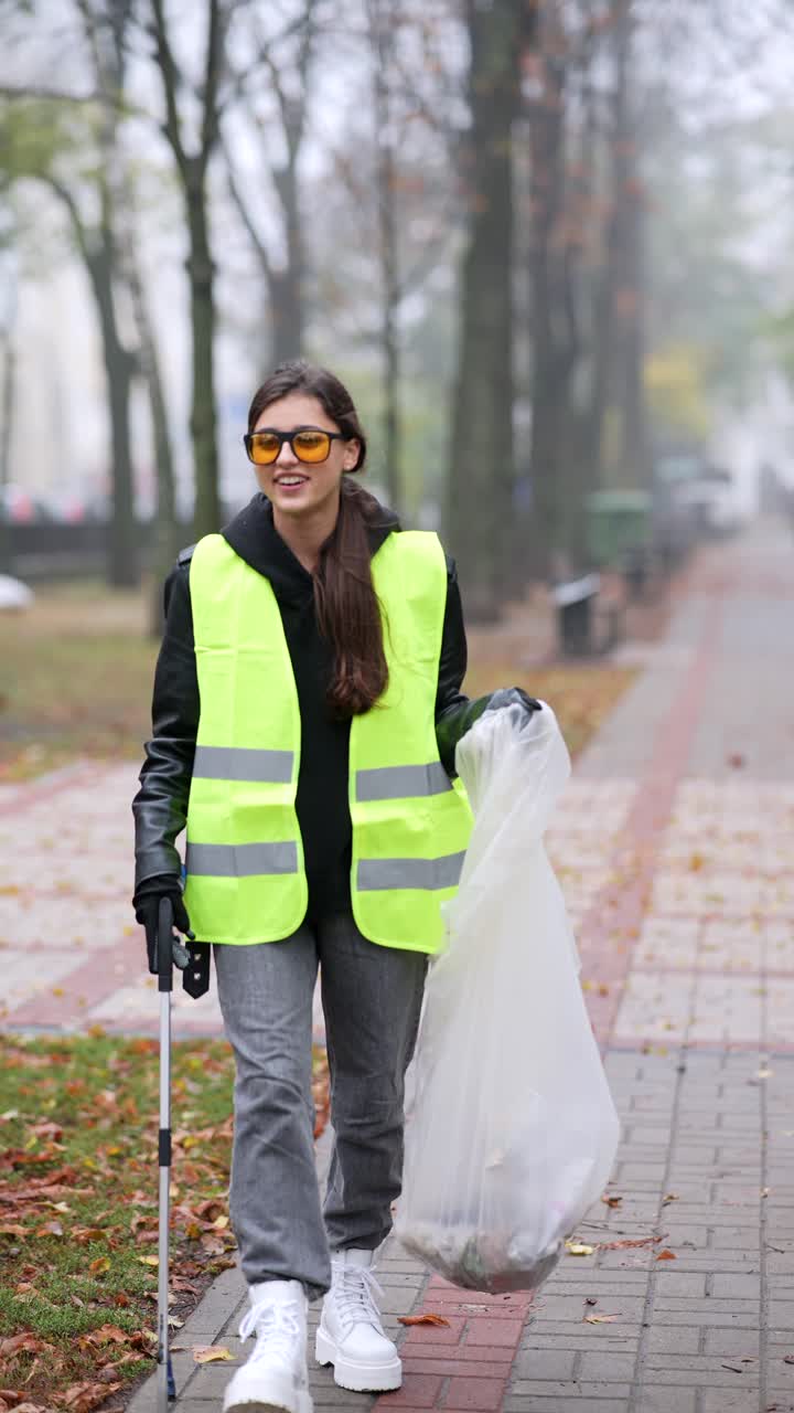 mujer limpiando la basura en un parque