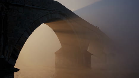 ancient stone bridge in misty sunrise