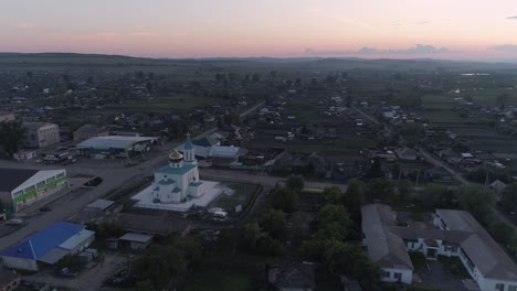 vista aérea de una iglesia en un pequeño pueblo ruso al atardecer