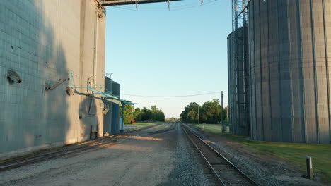 viaje cinematográfico a través de la carretera de la granja rural con contenedores de silos de grano a la vista