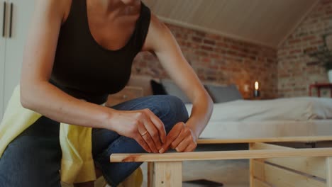 woman assembling a wooden bed frame