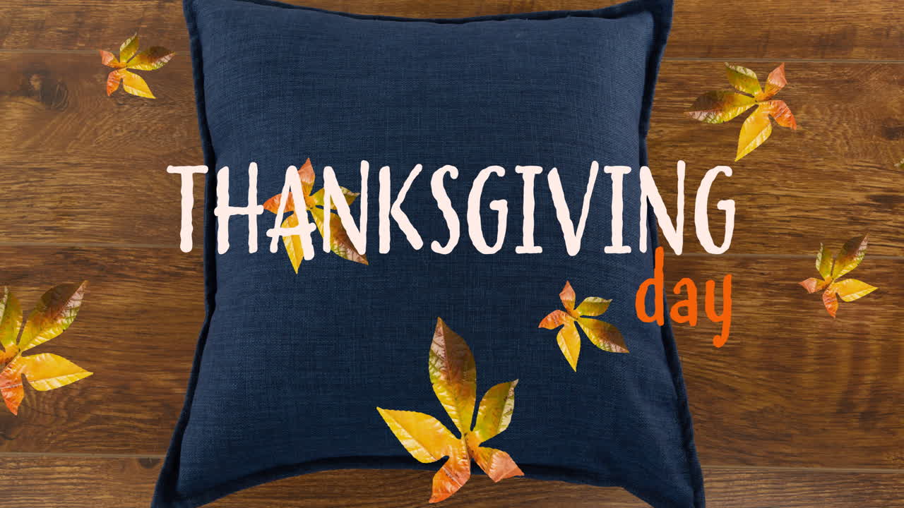 Animacja tekstu 'Thanksgiving Day' nad jesiennymi liśćmi i poduszką