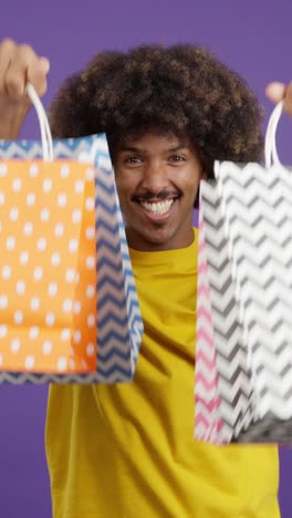 happy man displaying colorful shopping bags