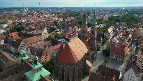 4k aerial drone video of the copper-clad twin spiers and stained glass windows of the beautiful st. sebald church in downtown nurnberg, germany