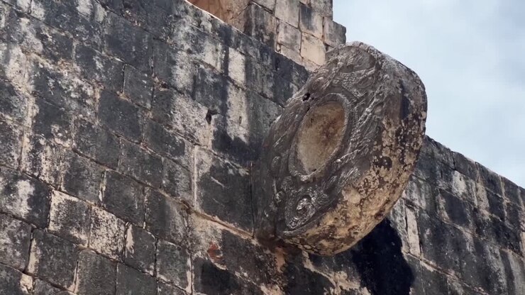 Handheld close-up tilting up shot of the stone ring above the Great Mayan Ball Court at Chichen Itza in Yucatan, Mexico. 4K