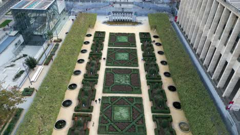 garden with square shaped bushes next to a statue in brussels aerial drone shot