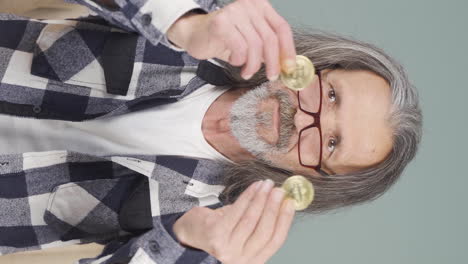 Vertical-video-of-Old-man-holding-bitcoin-and-showing-it.