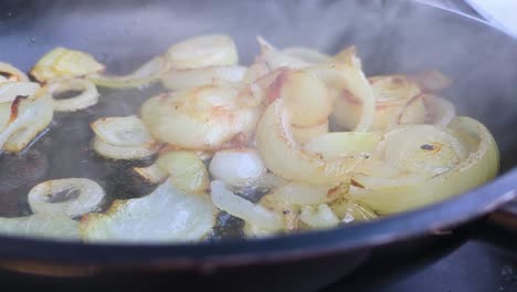 slow motion chopped white onions in hot pan with oil