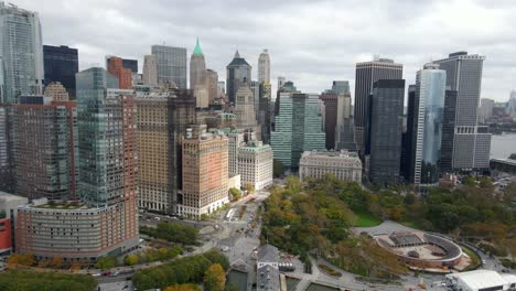 aerial view away from tall buildings in the lower manhattan cityscape, new york - pull back, drone shot