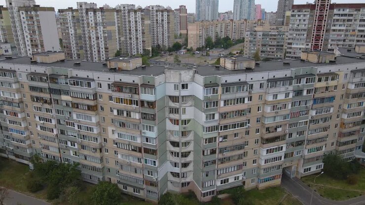Vista aérea afastando-se de antigos edifícios de apartamentos de fabricação soviética, dia nublado, em Kiev, Ucrânia - Recuo, tomada de drone