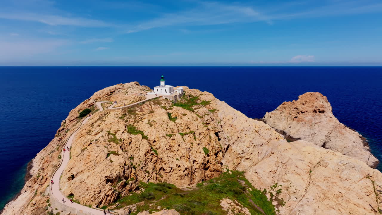 Aerial drone shot over Ile de la Pietra at the coastal town of Ile-Rousse in the Balagne region in Corsica, France. View of the White lighthouse on top of the cliff overlooking the landscape