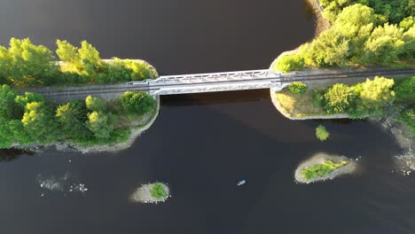 a view in which the camera is directly above the railway bridge leading over the river and gradually moves away from it