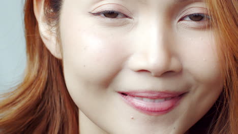 아파트에 주근깨가 있는 명랑하고 잘 생긴 젊은 빨간머리 여성은 카메라를 보고 진심으로 웃는다