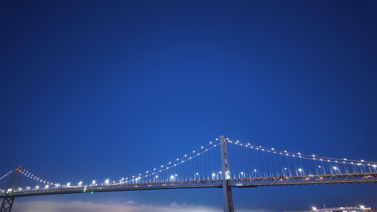 From a street-level vantage, this moving time-lapse frames the Bay Bridge as traffic flows in glowing patterns against a twilight backdrop.