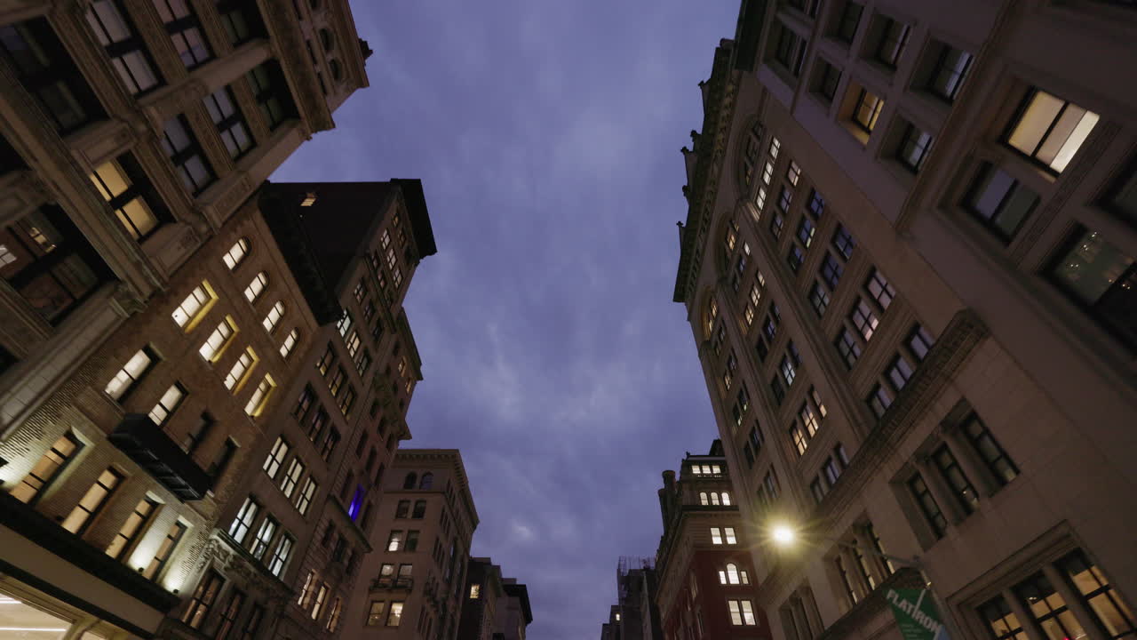 Inquadratura dal basso di edifici storici al crepuscolo a Manhattan, New York City, architettura classica e scena urbana serale.