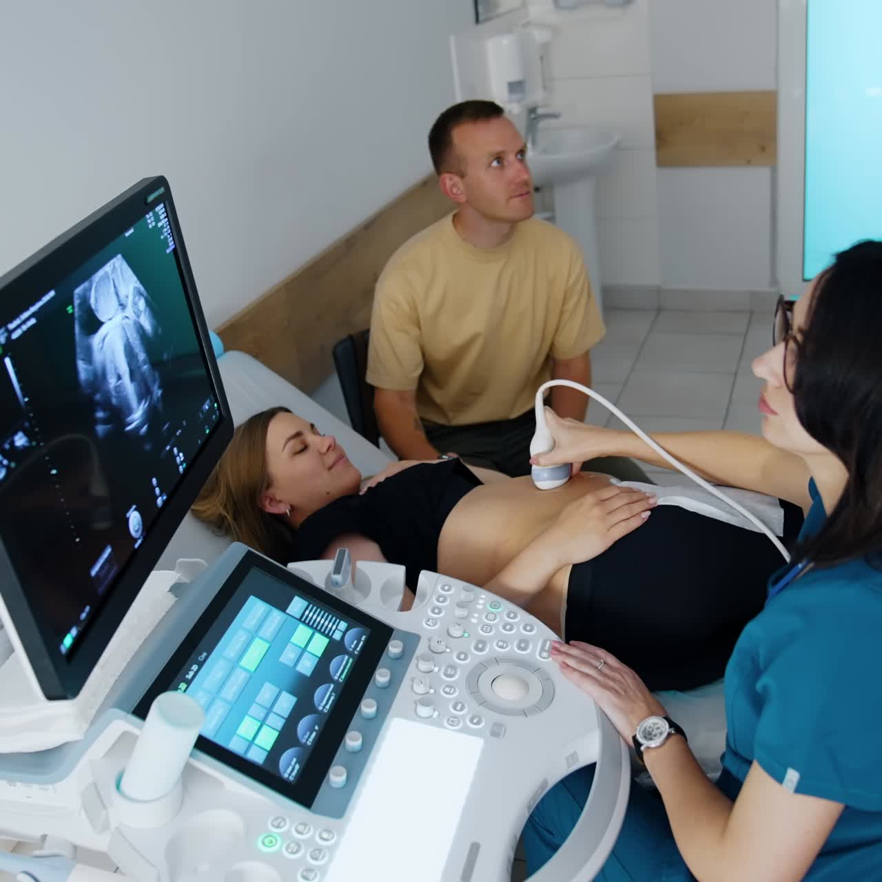 Coppia caucasica allo studio ecografico. La donna si sta sottoponendo a un controllo ecografico della gravidanza. Vista dall'alto