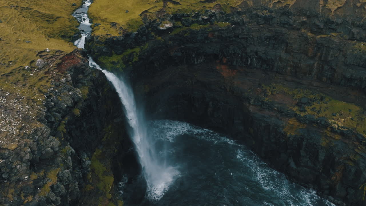 catarata de mulafossur, islas feroe: fantástica vista aérea desde la hermosa cascada y el viento golpeando el agua