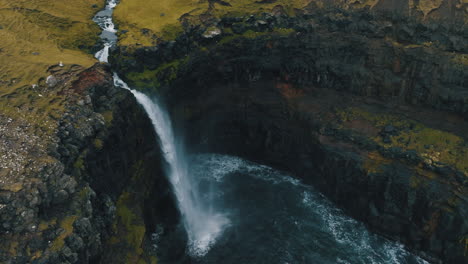 Cascada-De-Mulafossur,-Islas-Feroe:-Fantástica-Vista-Aérea-Apartando-La-Vista-De-La-Hermosa-Cascada-Y-El-Viento-Que-Golpea-El-Agua