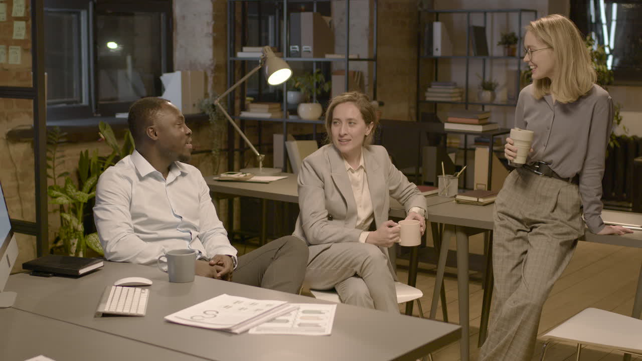 American Man Employee And Women Coworkers Talking In The Office