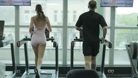 couple working out on treadmills in gym