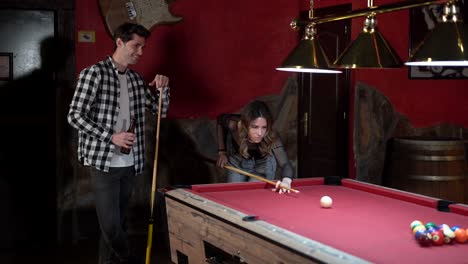 pareja feliz jugando al billar en un pub