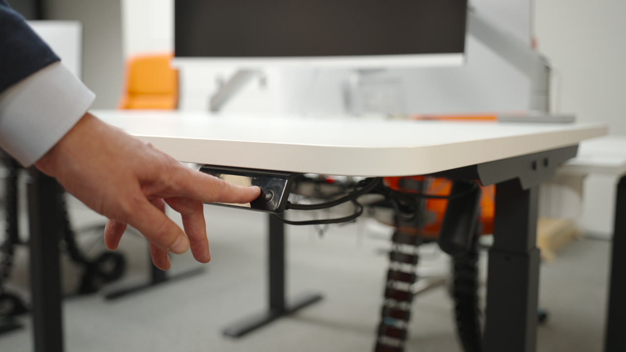 Caucasian Hand Presses Desk Control Under Tabletop, Toggling Height On Electric Standing Desk, Visible Cables. Creative