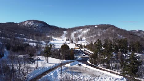 aerial shot approaching the winter ski slopes at morin heights, quebec, canada