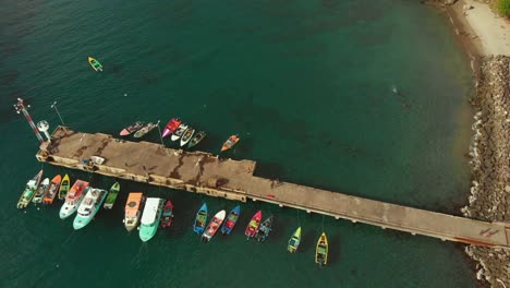 Vista-Aérea-De-Los-Barcos-De-Pesca-Que-Venden-Sus-Capturas-Junto-Al-Embarcadero-En-El-Mercado-De-Pescado-Gouyave-Ubicado-En-La-Isla-Caribeña-De-Granada,-También-Conocida-Como-La-Isla-De-Las-Especias