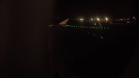 airplane wing seen from window while landing at night