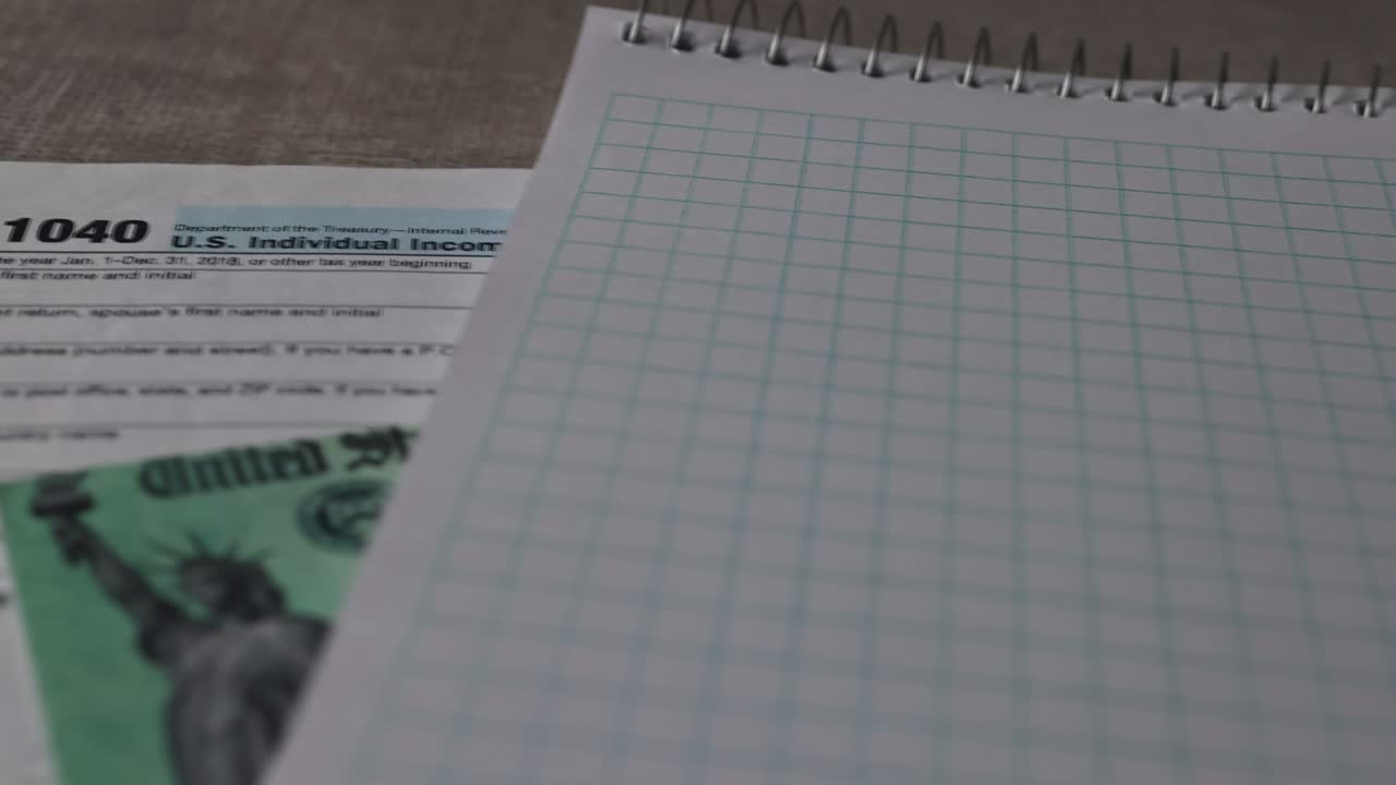 comprobación de retroceso de impuestos con moneda estadounidense y bloc de notas en espiral