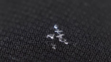 primer plano macro de copos de nieve aterrizados en pantalones negros en cámara lenta
