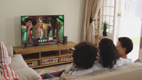 família afro-americana em casa usando tv digital fazendo chamada de vídeo no dia de são patrício