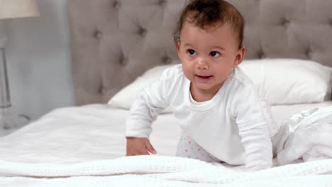 baby in white clothes crawling