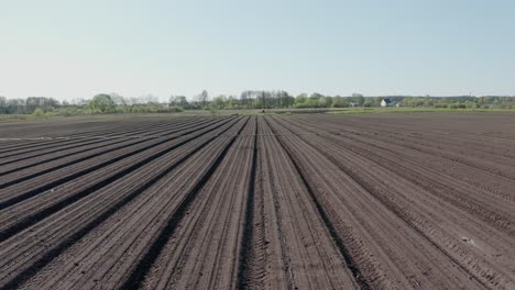 a tractor with blades cuts holes to prepare the field before fertilizing and seeding. agricultural machinery.