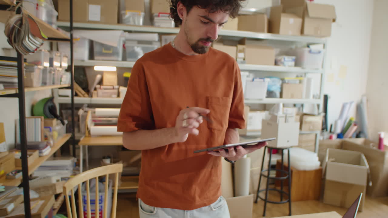 Man Using Tablet and Smiling on Camera in Delivery Service Office