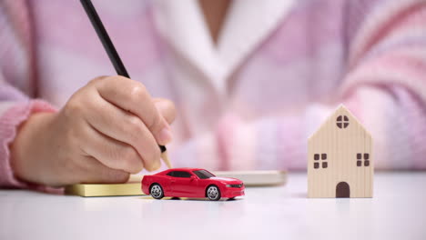 an individual planning and calculating the money needed for a new car and house on a loan