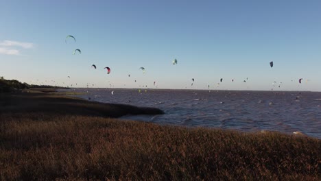 drone view of kitesurfers on the water - dolly zoom out