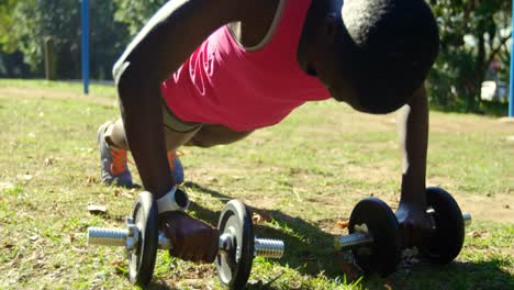 Female-athlete-doing-push-ups-in-the-park-4k