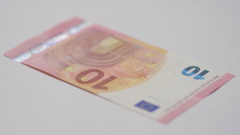 nahaufnahme einer währungsstudioaufnahme einer hand, die einen 10-euro-schein ergreift