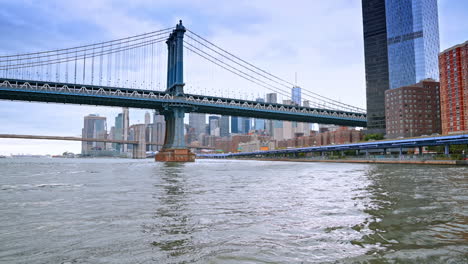 walk by the pier of the east river in new york, usa. low angle view on the manhattan bridge on a cloudy day
