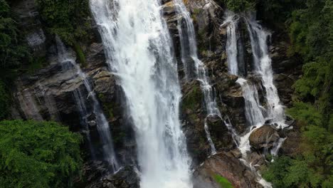 beautiful cinematic slow motion drone view over waterfall in green jungle