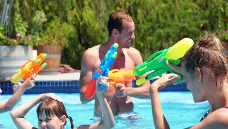 Familia-Feliz-Haciendo-Tiroteos-De-Agua-En-La-Piscina