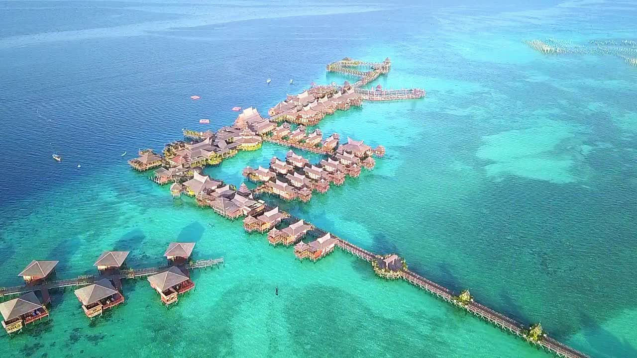 말레이시아의 크리스탈처럼 은 물과 리조트 위를 날아다니는 장거리 촬영은 느린 동작으로 앞으로 이동합니다.