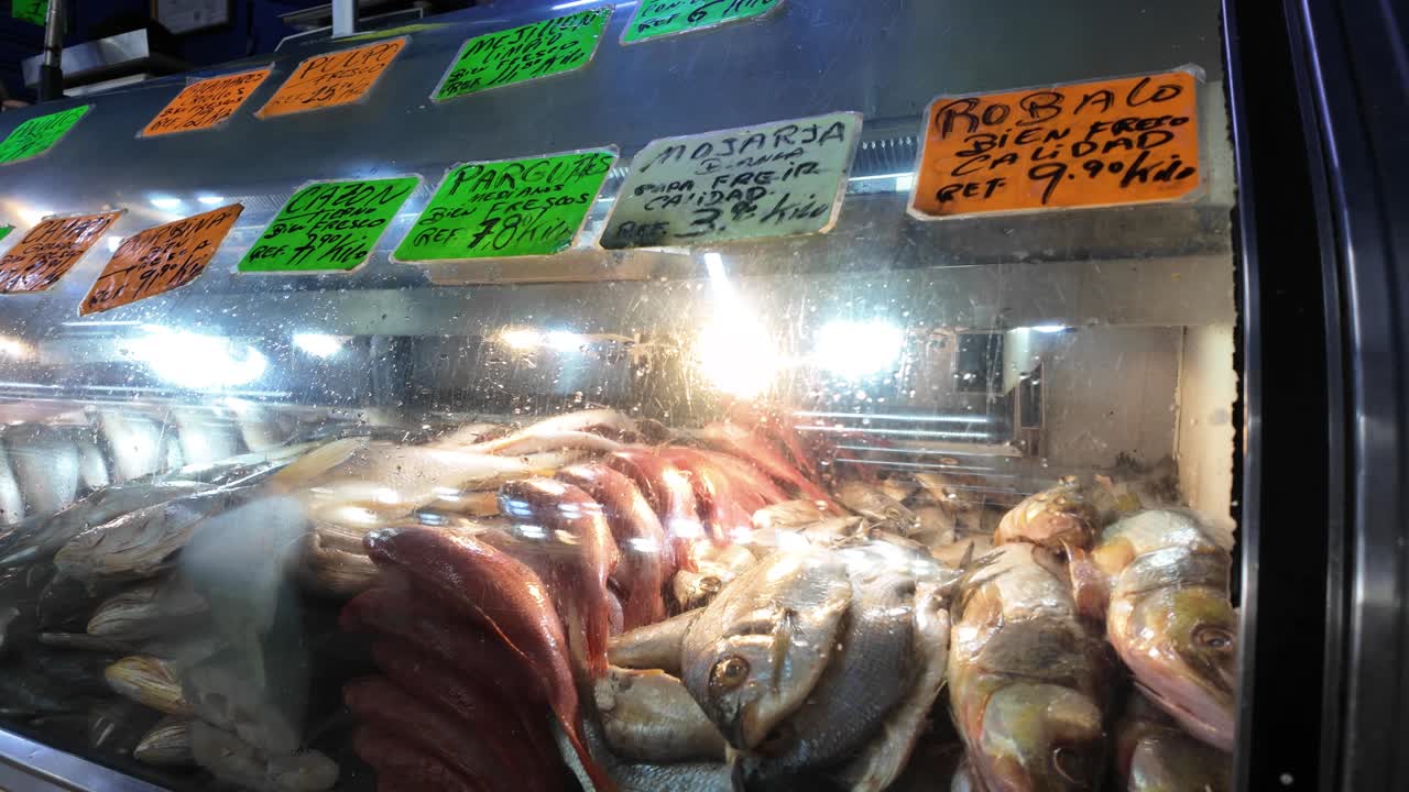 Capturing the raw energy and colorful variety of a local market stall, with handwritten signs and glistening fresh fish on ice