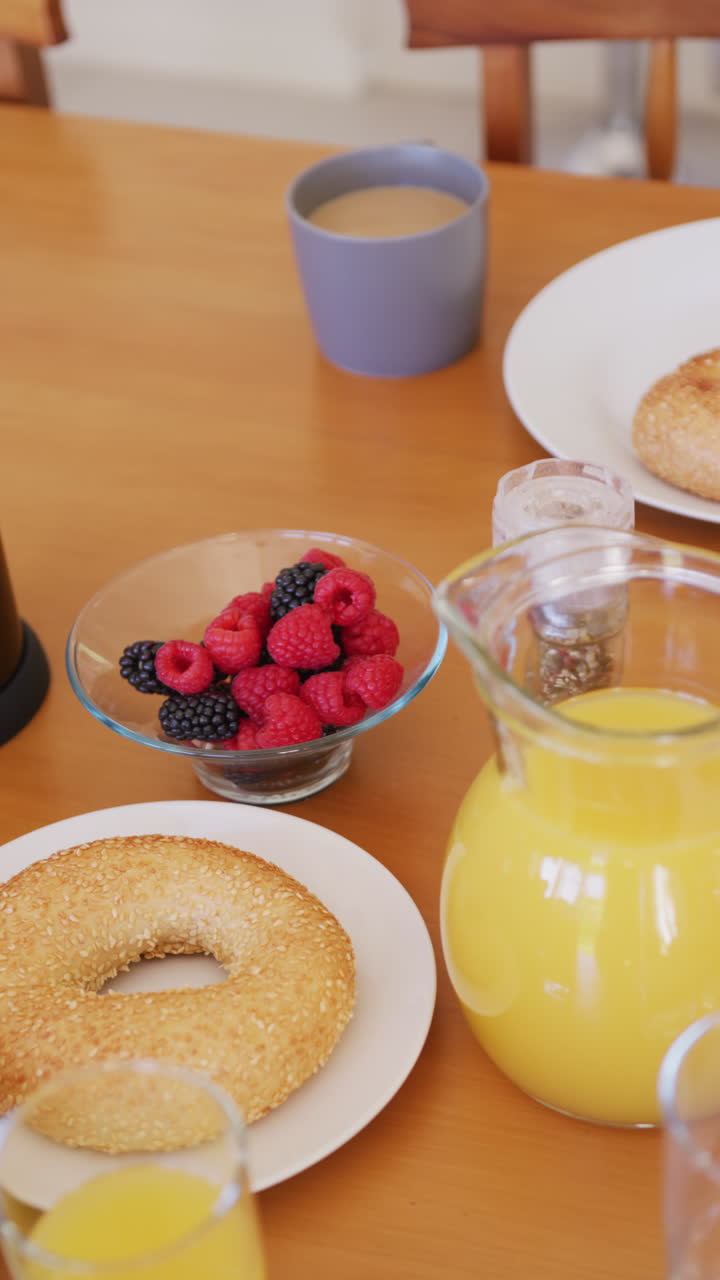 Vertical video of fresh bread and fruit on breakfast with coffee and orange juice on table