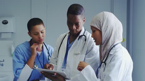 Front-view-of-Multi-Ethnic-doctors-discussing-over-medical-report-in-hospital