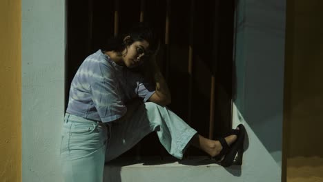 Woman-sitting-alone-on-a-doorstep-at-night