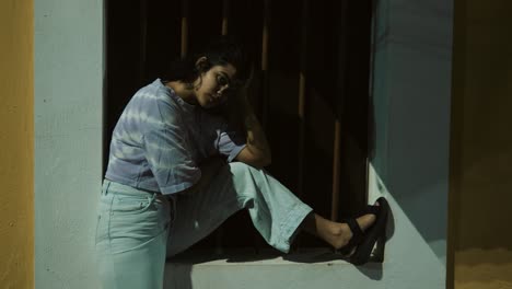 mujer sentada sola en una puerta por la noche